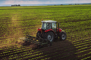A tractor plowing a large field