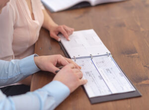 Two people sitting at a table with a business checkbook in front of them