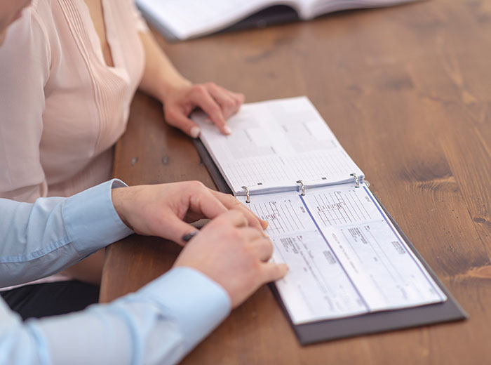 Two people sitting at a table with a business checkbook in front of them